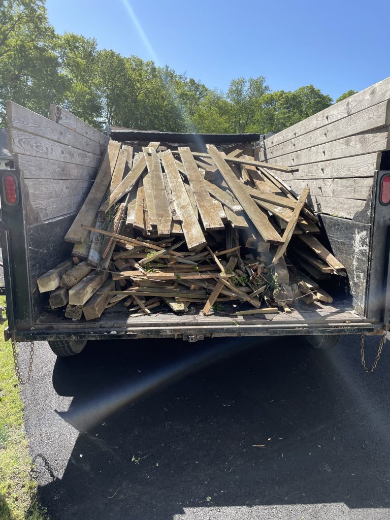 15 yard dumpster from C&L junk Removal full with old deck boards