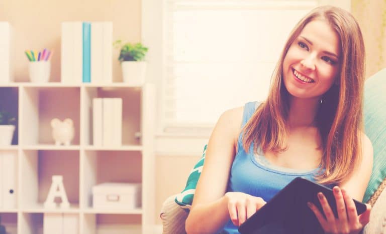Person sitting with tablet in room.